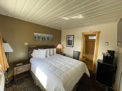 a bedroom with a large white bed in a room at Estes Mountain Inn in Estes Park