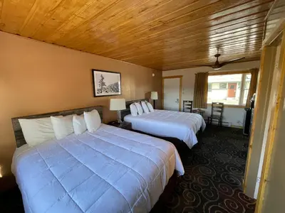a hotel room with two beds and a window at Estes Mountain Inn in Estes Park
