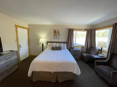 a hotel room with a bed and a chair at Estes Mountain Inn in Estes Park