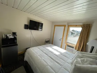 a bedroom with a white bed and a window at Estes Mountain Inn in Estes Park
