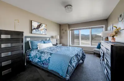 a bedroom with a bed and a dresser and a window at Lake Dillon Retreat Townhome: Panoramic Lake, Mountain Views in Dillon