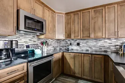 a kitchen with wooden cabinets and a stove top oven at Lake Dillon Retreat Townhome: Panoramic Lake, Mountain Views in Dillon