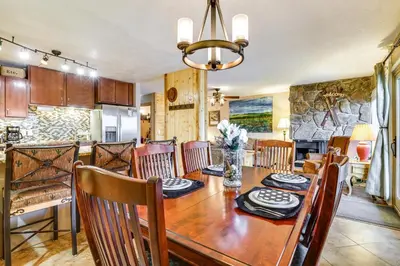 a dining room and kitchen with a wooden table and chairs at 1 Mi to Marina Frisco Condo with Mtn-View Balcony! in Frisco