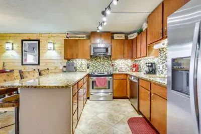 a kitchen with wooden cabinets and a stove top oven at 1 Mi to Marina Frisco Condo with Mtn-View Balcony! in Frisco