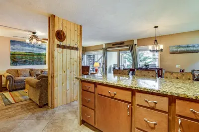a kitchen with a counter and a living room at 1 Mi to Marina Frisco Condo with Mtn-View Balcony! in Frisco