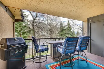 a screened in porch with chairs and a grill at 1 Mi to Marina Frisco Condo with Mtn-View Balcony! in Frisco