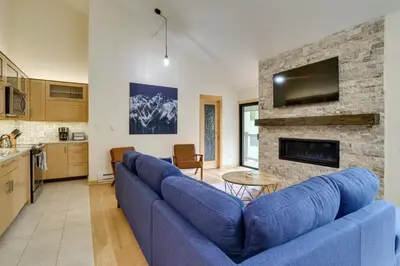 a living room with a blue couch and a fireplace at Ski Retreat Keystone Resort Condo with Heated Pool! in Keystone