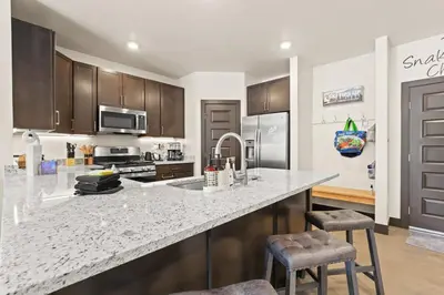 a kitchen with a large marble counter top with two bar stools at The Snake River Chalet in Keystone