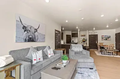 a living room with a couch and a cow on the wall at The Snake River Chalet in Keystone