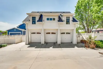 a white house with two garage doors and a fence at 14 Mi to Dtwn Denver Sleek Westminster Home in Westminster