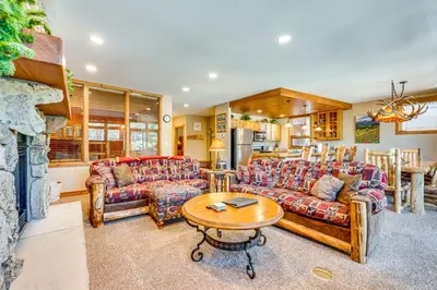 a living room with two couches and a table at Walk to Gondola Condo with Deck in Winter Park! in Winter Park