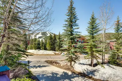 a view of a driveway with trees and a house at Walk to Gondola Condo with Deck in Winter Park! in Winter Park