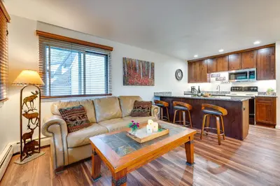 a living room with a couch and a table at Estes Park Condo Rental Balcony with River Views! in Estes Park