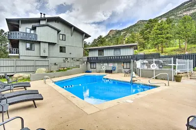a swimming pool in front of a house at Estes Park Condo Rental Balcony with River Views! in Estes Park