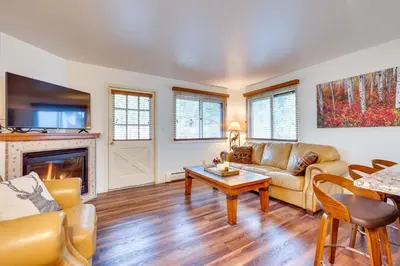 a living room with a couch and a fireplace at Estes Park Condo Rental Balcony with River Views! in Estes Park