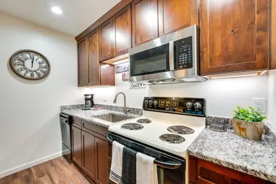 a kitchen with a stove and a microwave at Estes Park Condo Rental Balcony with River Views! in Estes Park