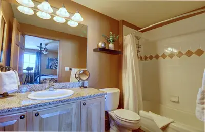 a bathroom with a sink and a toilet and a mirror at E8 Drake Landing 2Br Loft condo in Frisco