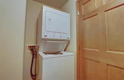 a washing machine with a microwave on top of it at E8 Drake Landing 2Br Loft condo in Frisco