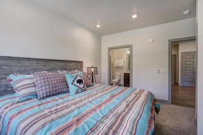 a bedroom with a large bed with a dog on it at Clearwater Lofts - 3 Bedroom Luxury Condo Near Lakeside Village in Keystone
