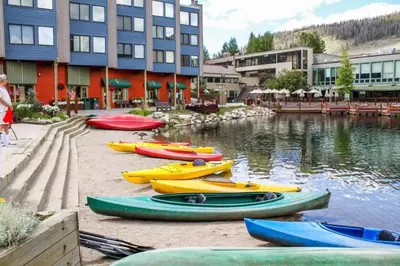 a group of kayaks are lined up next to the water at Clearwater Lofts Luxury 1 Bed Condo Near Lakeside Village in Keystone
