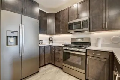 a kitchen with stainless steel appliances and wooden cabinets at Clearwater Lofts Luxury 1 Bed Condo Near Lakeside Village in Keystone