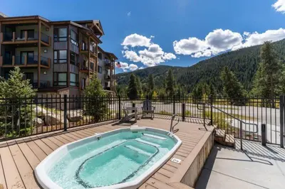 a hot tub on a deck next to a building at Clearwater Lofts Luxury 1 Bed Condo Near Lakeside Village in Keystone