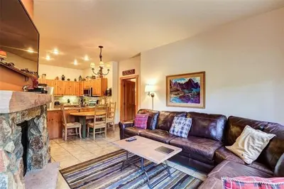 a living room with a leather couch and a fireplace at River Run Village Condos - 2 Bedroom - Walk To Lift! in Keystone