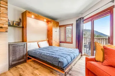 a bedroom with a bed and a couch and a balcony at River Run Village 2 Bedroom At Red Hawk in Dillon