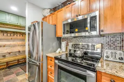 a kitchen with stainless steel appliances and wooden cabinets at River Run Village 2 Bedroom At Red Hawk in Dillon