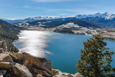 a view of a blue lake with snow covered mountains at River Run Village 2 Bedroom At Red Hawk in Dillon