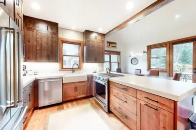a large kitchen with wooden cabinets and stainless steel appliances at Red Hawk Townhomes 4 Bedroom - 200 Yards To Gondola! in Dillon