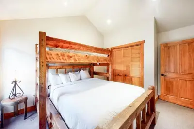 a bedroom with a large bed with a wooden frame at Red Hawk Townhomes 4 Bedroom - 200 Yards To Gondola! in Dillon