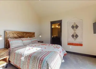 a bedroom with a bed and a quilt hanging on the wall at River Run Townhomes - 3 Bedroom - Walk To Slopes! in Keystone