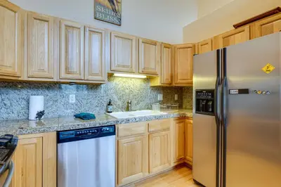 a kitchen with wooden cabinets and a stainless steel refrigerator at Fraser Vacation Rental 6 Mi to Ski Resort in Fraser