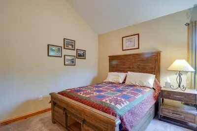 a bedroom with a bed and a night stand with a lamp at Fraser Vacation Rental 6 Mi to Ski Resort in Fraser