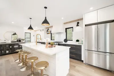 a kitchen with a large white counter and stools at Ski Shores cabin in Grand Lake