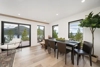 a dining room with a table and chairs and windows at Ski Shores cabin in Grand Lake