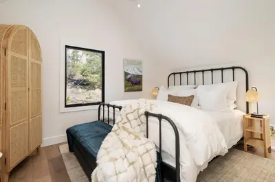 a bedroom with a large white bed and a window at Ski Shores cabin in Grand Lake
