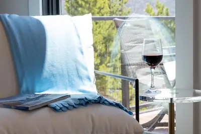 a glass of wine sitting on a chair next to a window at Ski Shores cabin in Grand Lake