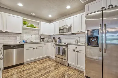 a kitchen with white cabinets and stainless steel appliances at 2 Bedroom townhome, super close to downtown FC! in Fort Collins