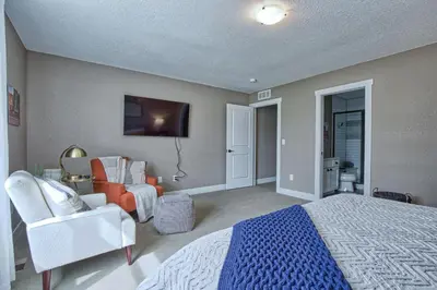 a bedroom with a bed and a chair and a tv at 2 Bedroom townhome, super close to downtown FC! in Fort Collins