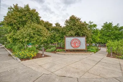 a sign in a garden with trees and flowers at 2 Bedroom townhome, super close to downtown FC! in Fort Collins