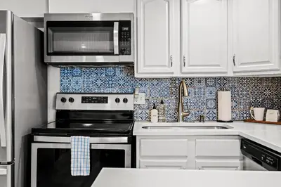 a kitchen with a stove and a microwave at Contemporary Finishes - Studio Apt - Sloans Lake in Denver