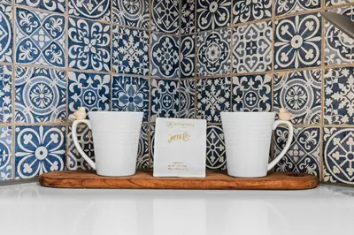 three coffee mugs on a shelf in front of a wall at Contemporary Finishes - Studio Apt - Sloans Lake in Denver