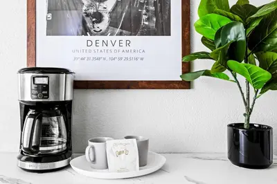 a coffee maker and cups on a counter with a plant at New Stylish Sanctuary - King Beds - Sloans Lake in Denver