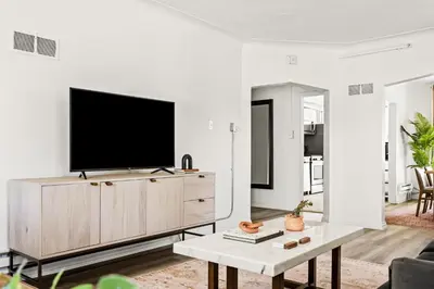 a living room with a tv on a white wall at Modern Comfort - King Beds - Walk to Sloans Lake in Denver
