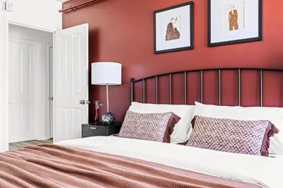 a bedroom with red walls and a bed with pillows at Modern Comfort - King Beds - Walk to Sloans Lake in Denver