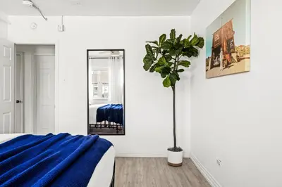 a bedroom with a blue bed and a mirror at Bright & Modern Retreat - King Beds - Sloans Lake in Denver