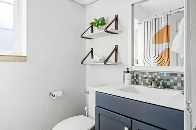 a bathroom with a sink and a toilet and a mirror at Bright & Modern Retreat - King Beds - Sloans Lake in Denver