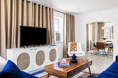 a living room with a flat screen tv on a white cabinet at Bright & Modern Retreat - King Beds - Sloans Lake in Denver